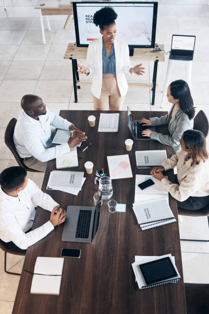 Business meeting, presentation and people above for conference, seminar or workshop in corporate training. Professional black woman, manager or speaker speaking to clients, employees or company staff
